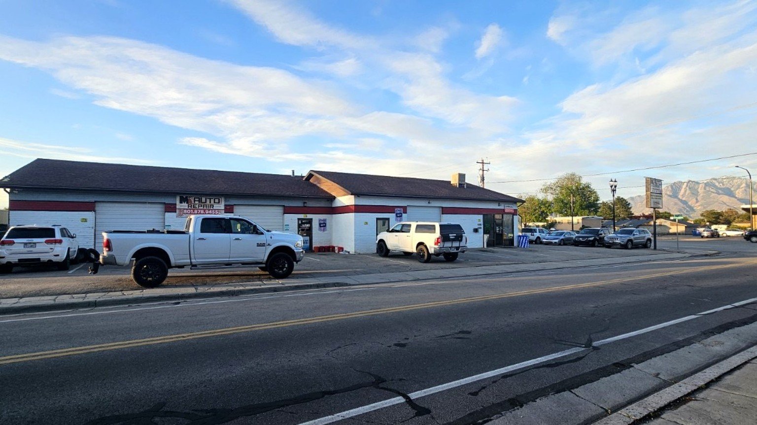 M1 Auto Repair shop exterior on Redwood Road in West Jordan, UT — service bays, trucks, and Wasatch Mountains
